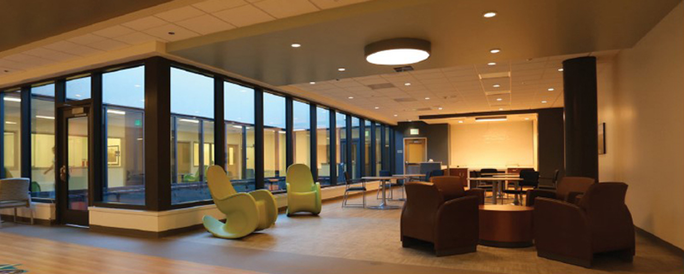 Interior photo of a behavioral health unit, with assorted chairs and lots of windows.