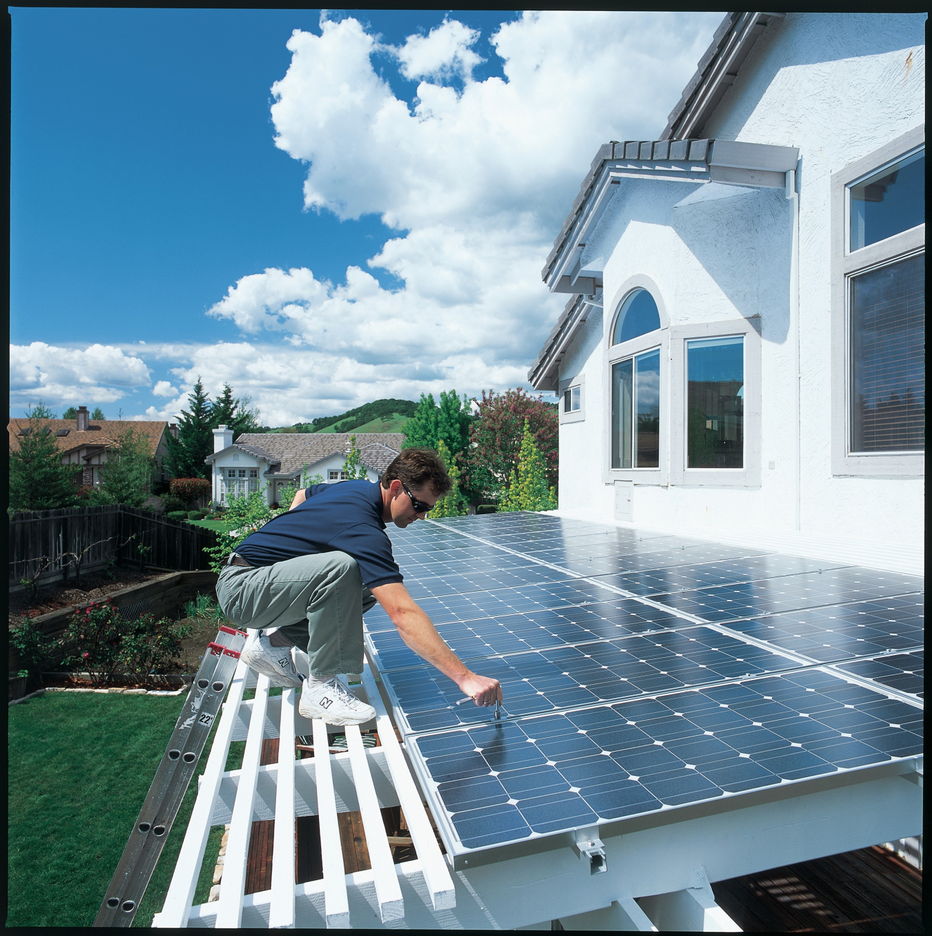 Man installing PV integrated into a solar awning over a back porch in California