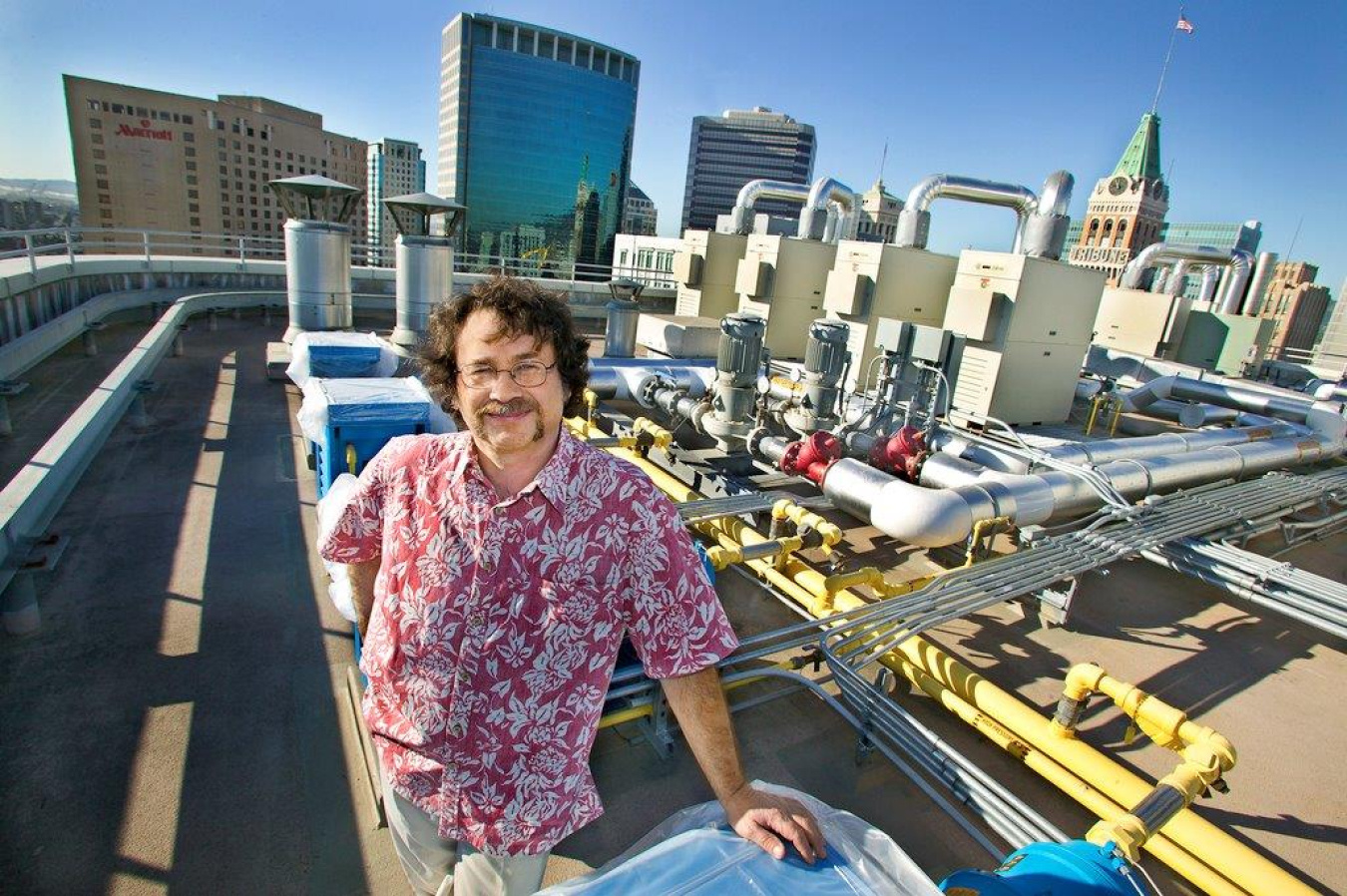 Lab researcher stands on the rooftop overlooking the city of Oakland.