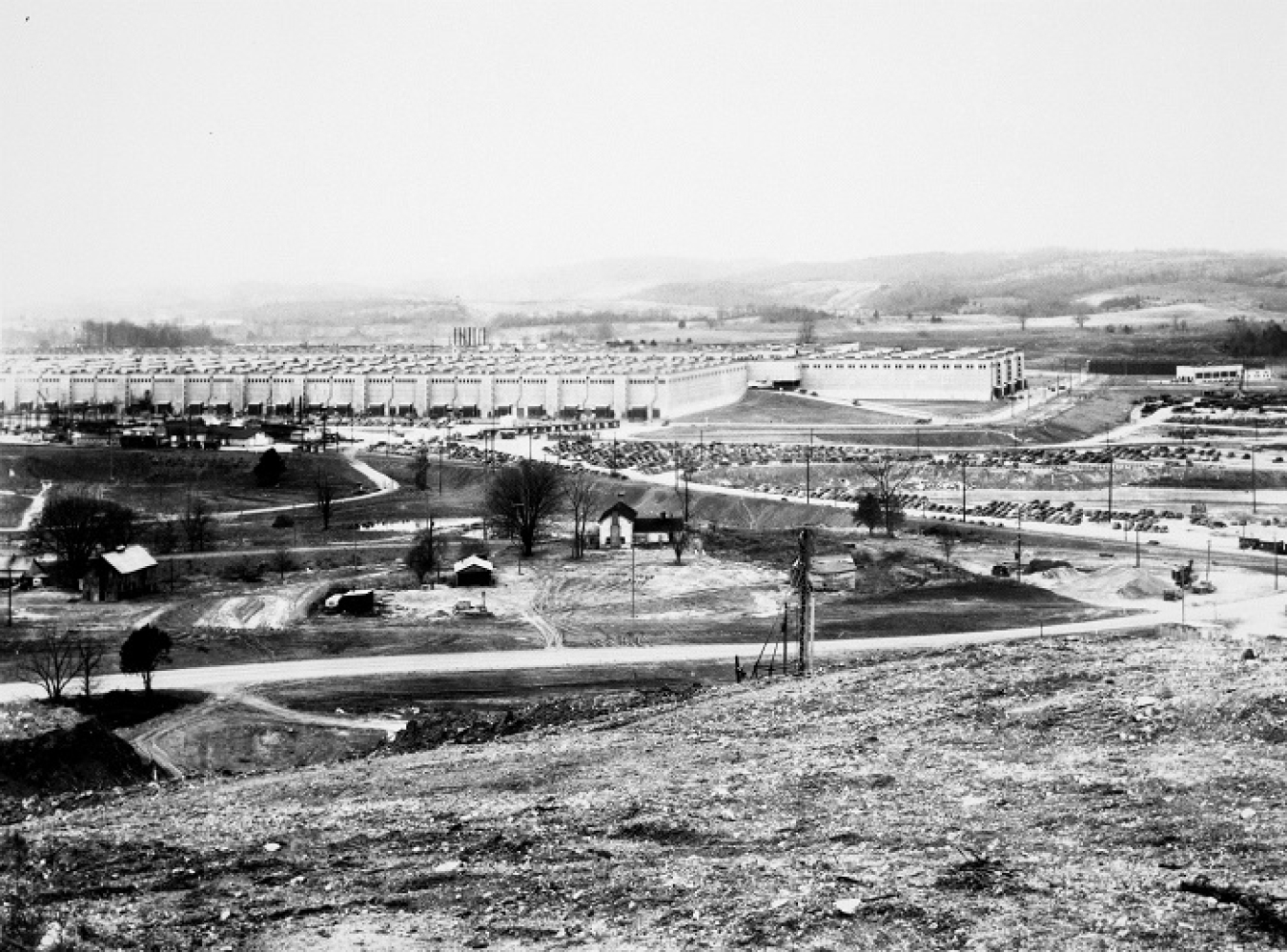This picture taken in the 1940s shows the K-25 Building sitting behind some of the still-standing farm houses that previously belonged to Wheat community residents who were relocated to make room for the massive wartime effort.