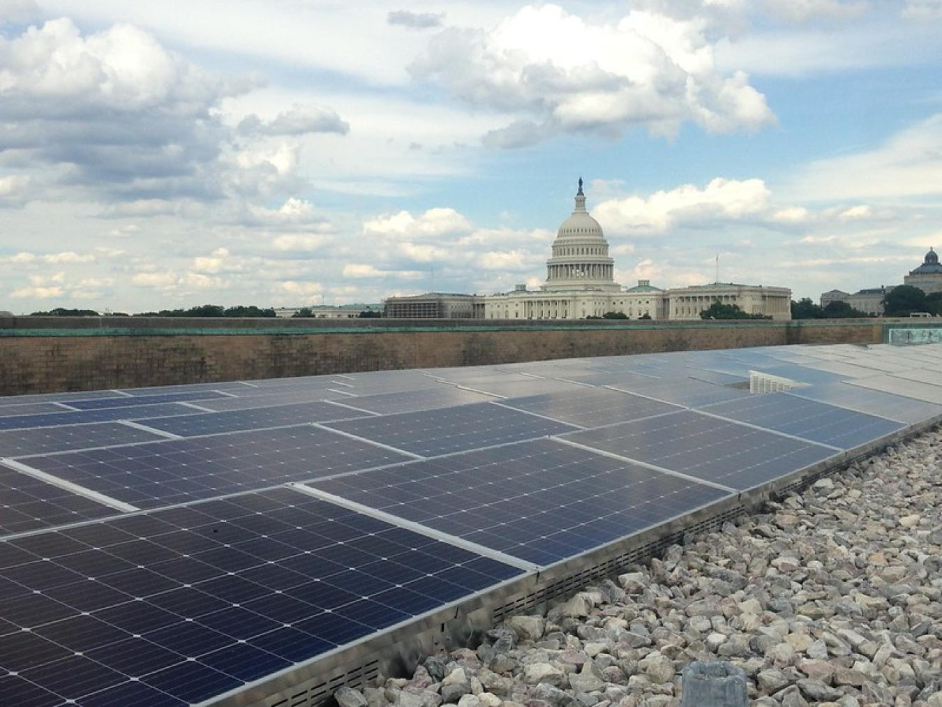 Solar panels on a government building roof with the U.S. Capitol in the background