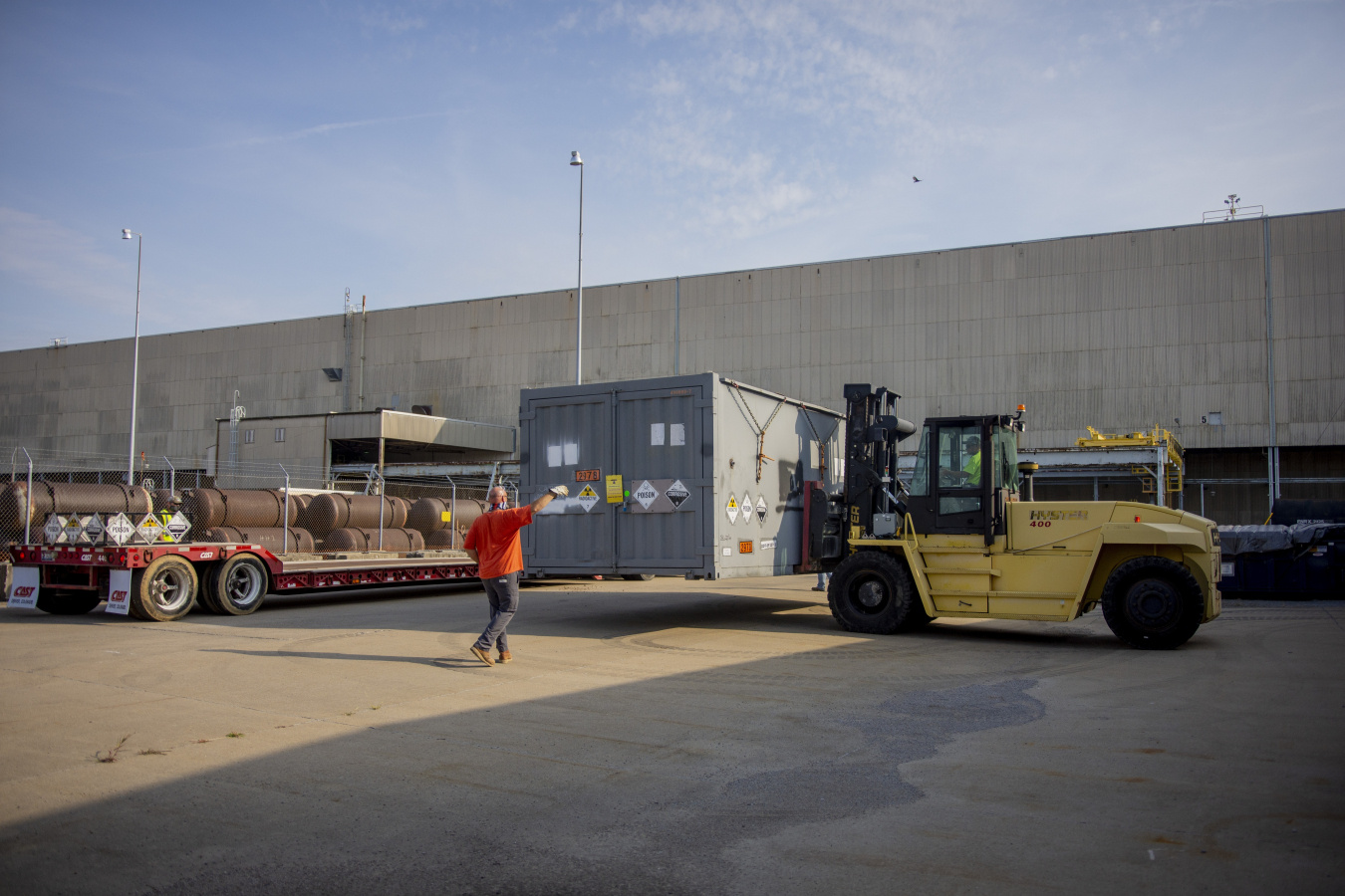 Paducah Site contractor maintenance mechanic Matt Wheeler spots Heavy Equipment Operator Ryan Jackson as a cold trap is lowered onto a shipping trailer outside the storage facility.