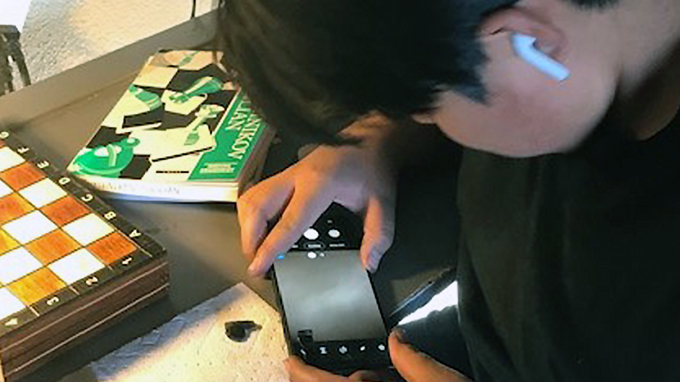 students examines object using smartphone microscope.