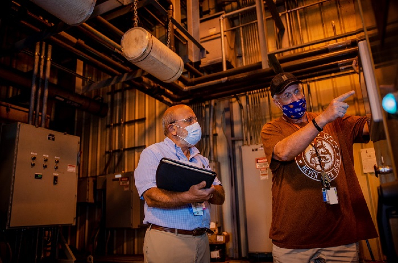 Paducah Site workers Joe Tarantino and Denver Parman discuss the operation and maintenance of the pump-and-treat equipment used at the site.