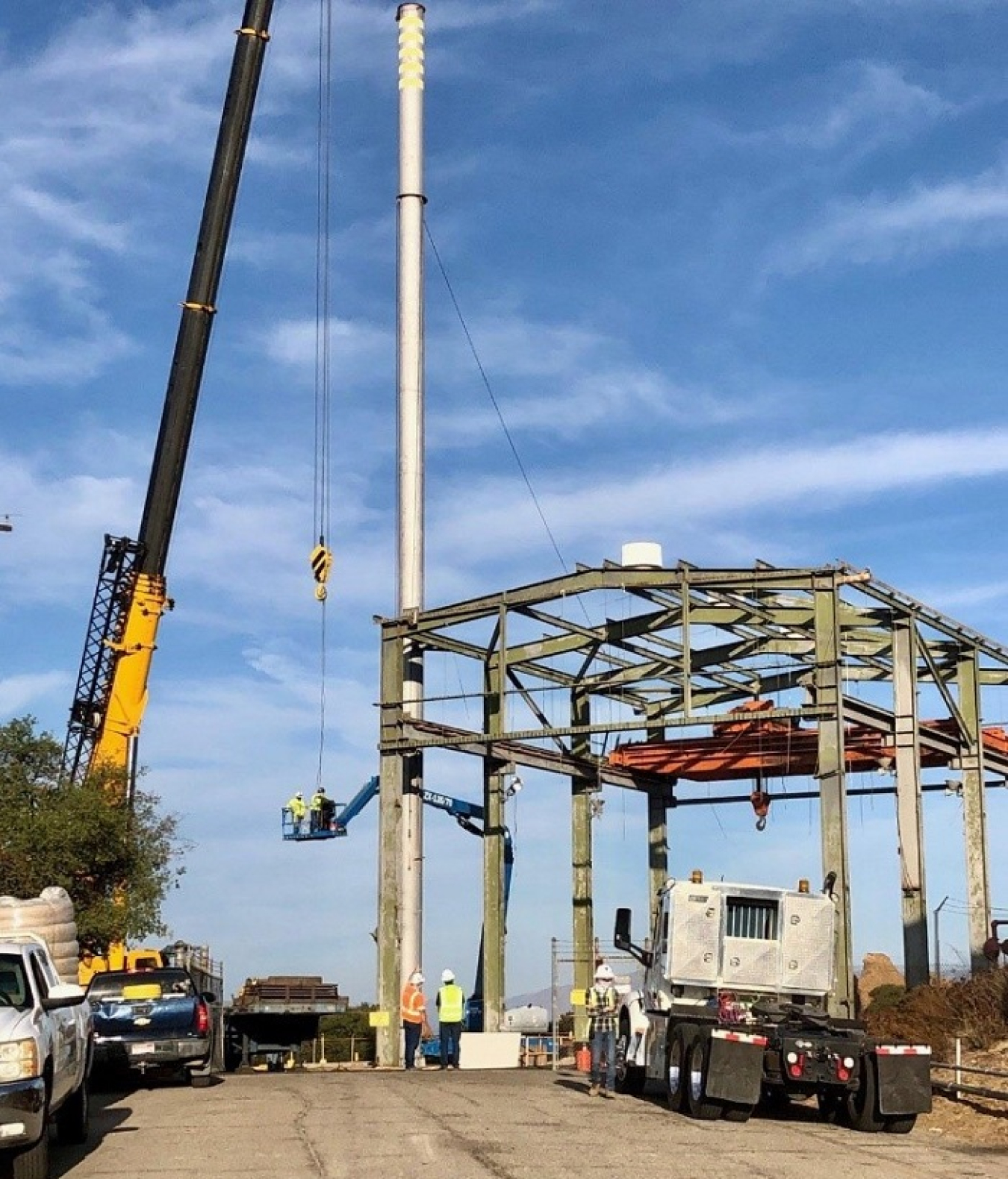 A crew tears down a stack attached to Building 4022 at the Radioactive Materials Handling Facility (RMHF) at the Energy Technology Engineering Center. Teardown of the structure marked the completion of demolition of a set of 10 buildings at the RMHF.
