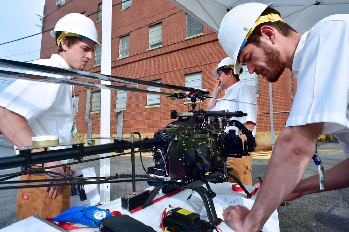 A close-up view of the drone, which resembles a mini-helicopter. Following commands from a ground-based operator, the camera-mounted drone circles around the stack making recordings that can be evaluated by engineers and safety experts.