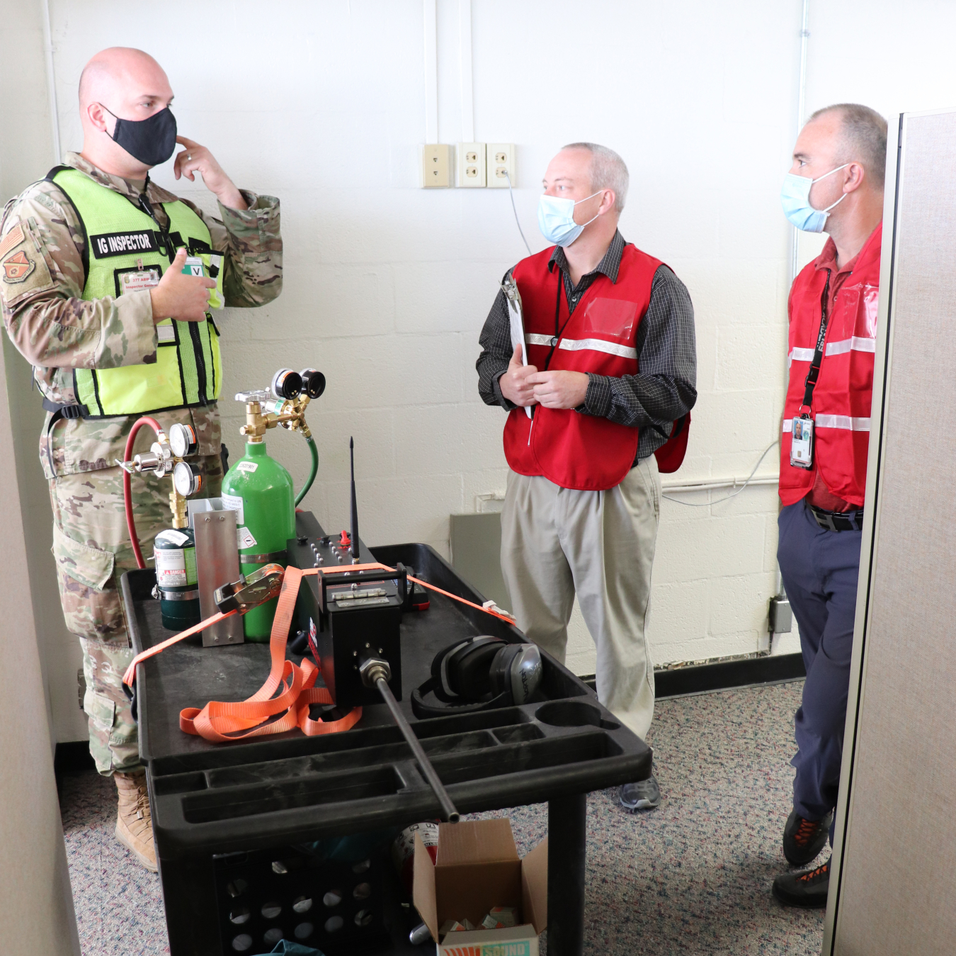 NNSA Albuquerque Complex Management Team employees Kevin McElvany and Timothy “Ozzy” Oswald confer with the operator of the gun simulator machine used during the exercise.