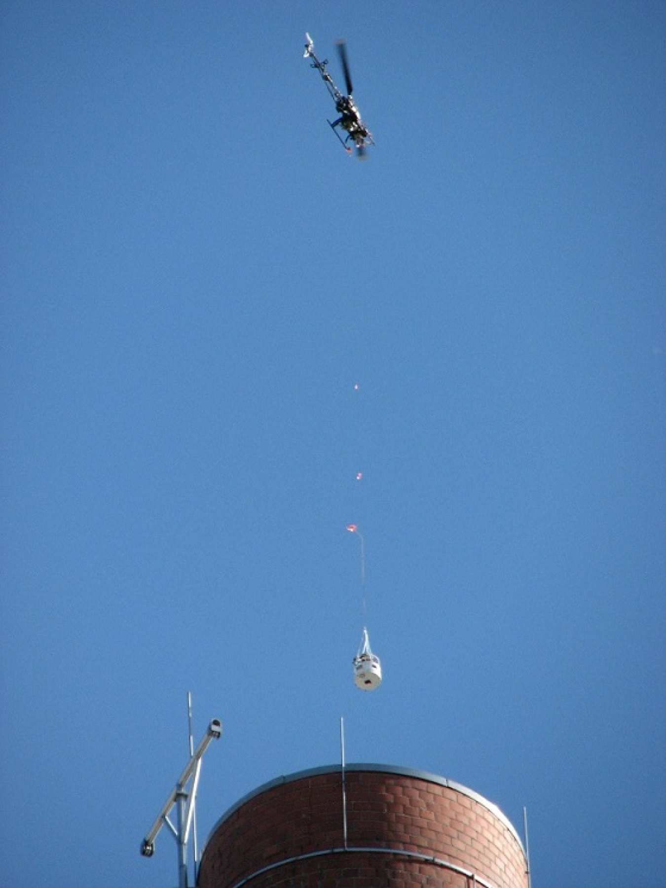 A drone hovers over the 3039 exhaust stack at Oak Ridge to lower a camera inside to conduct a visual inspection.
