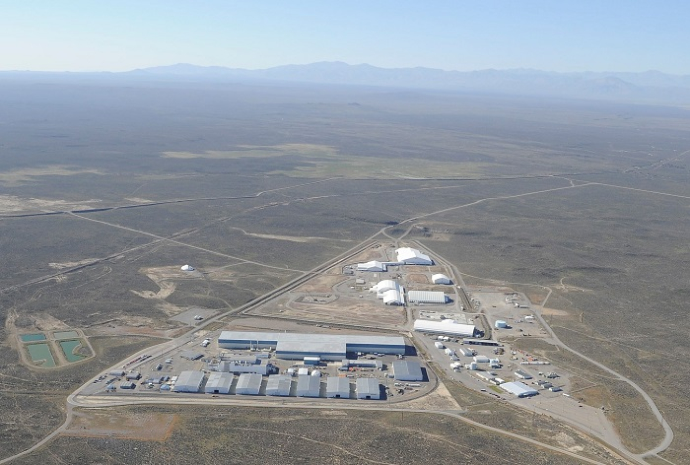 The Transuranic Storage Area Retrieval Enclosure — the wide T-shaped building in the foreground — is undergoing closure under federal and state regulations at the Radioactive Waste Management Complex at the Idaho National Laboratory Site. 