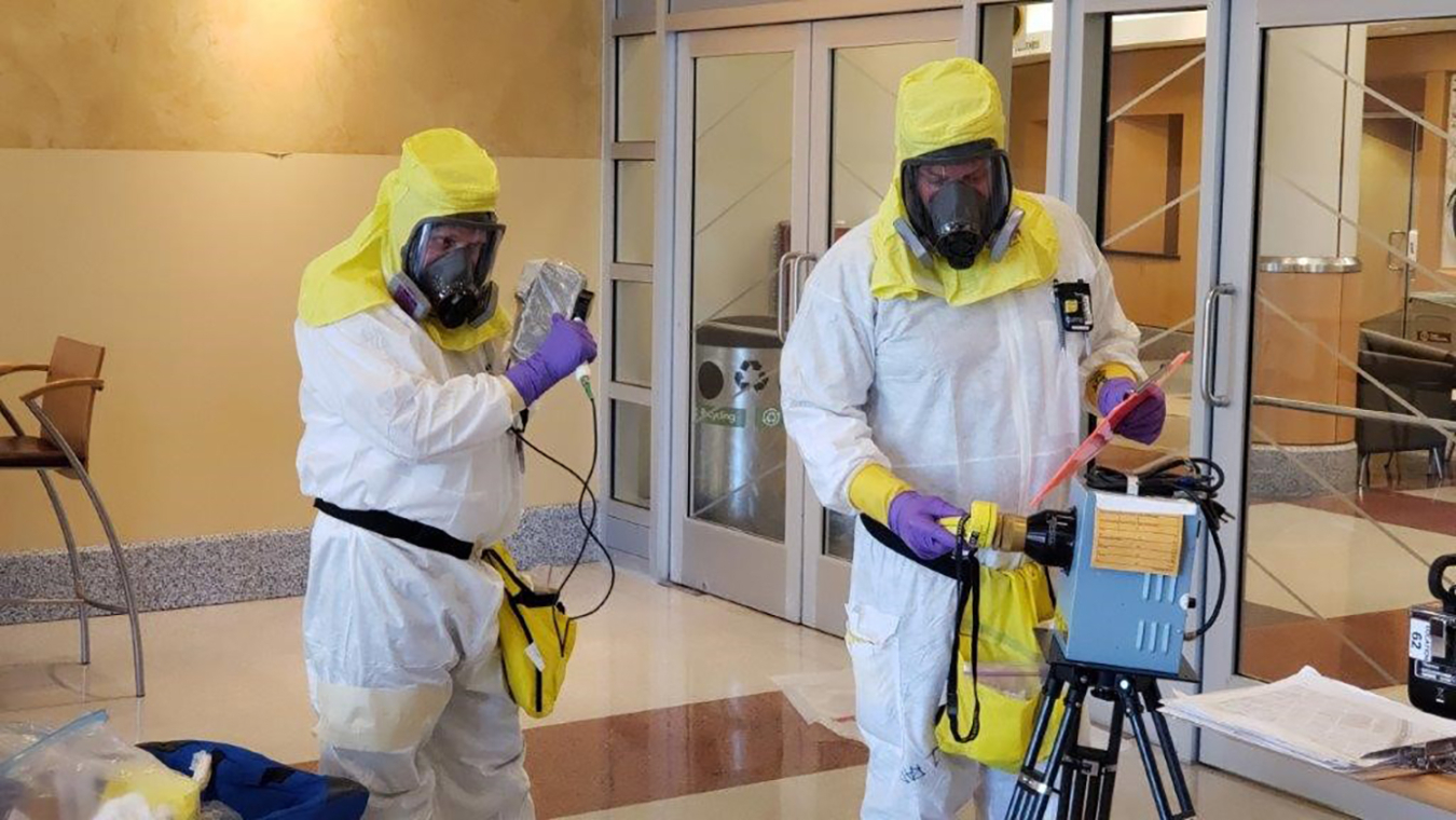 Experts in protective gear prepare to sweep the University of Washington's Research and Training Building for cesium contamination.