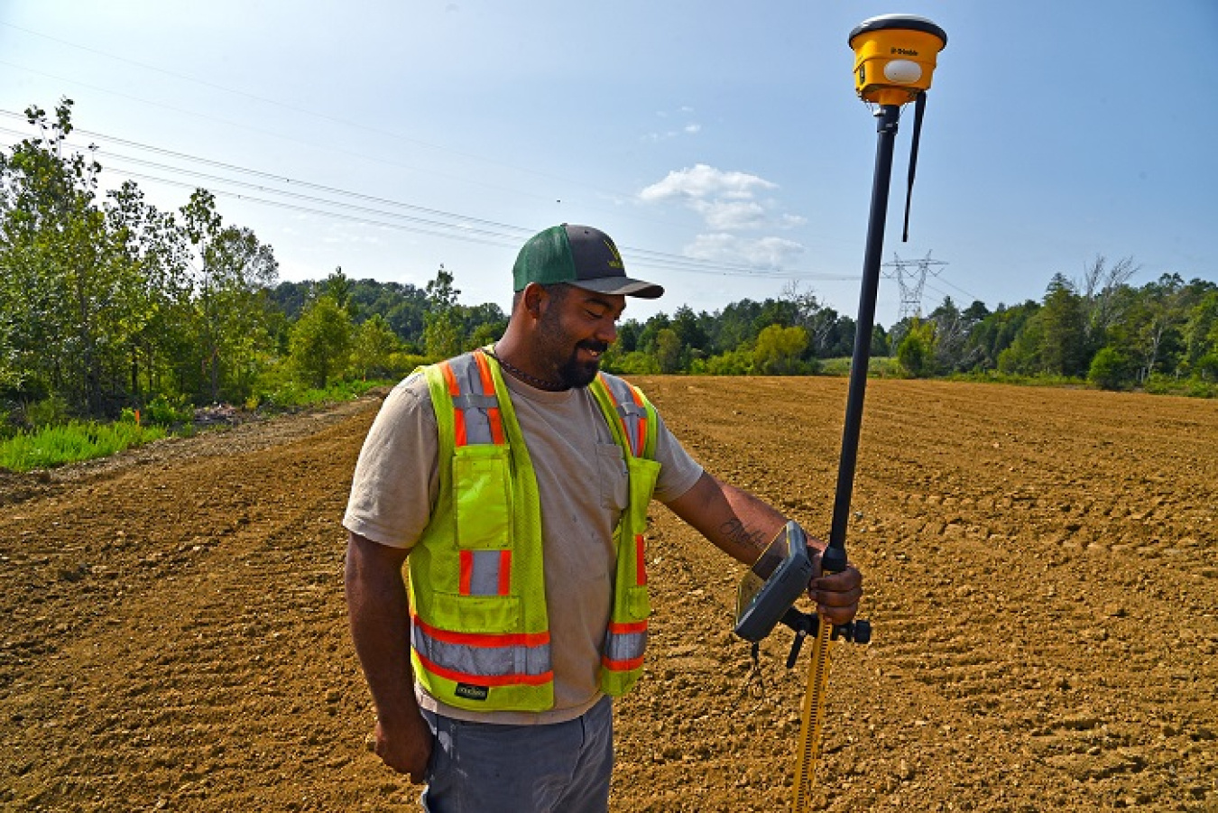 An EM worker relies on a handheld device with GPS technology to ensure precise soil coverage over the various contours of a former oil tank farm site at Oak Ridge.