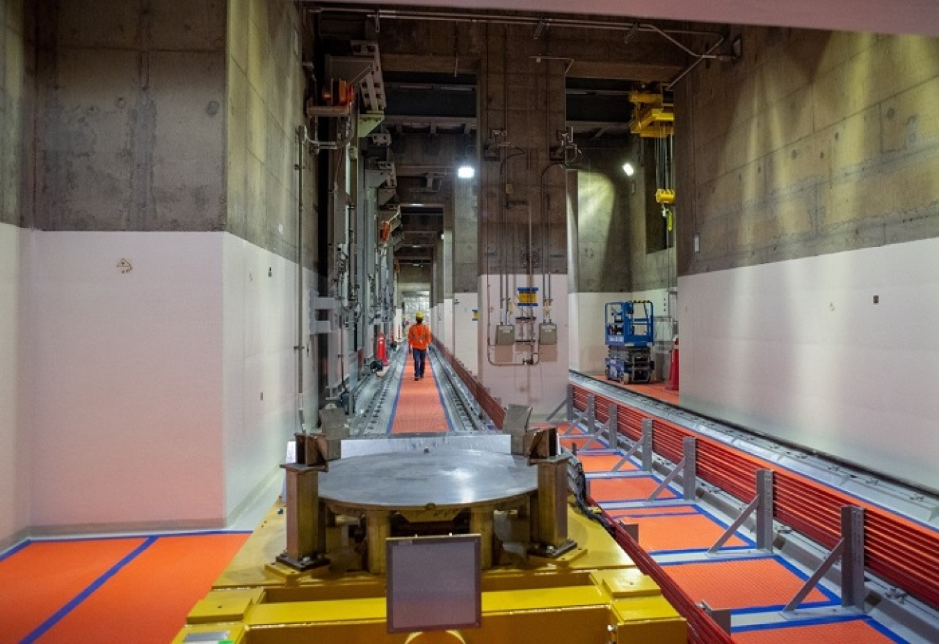 A worker walks along a mechanical line for moving containers in the basement of the Waste Treatment and Immobilization Plant’s Low-Activity Waste (LAW) Facility.