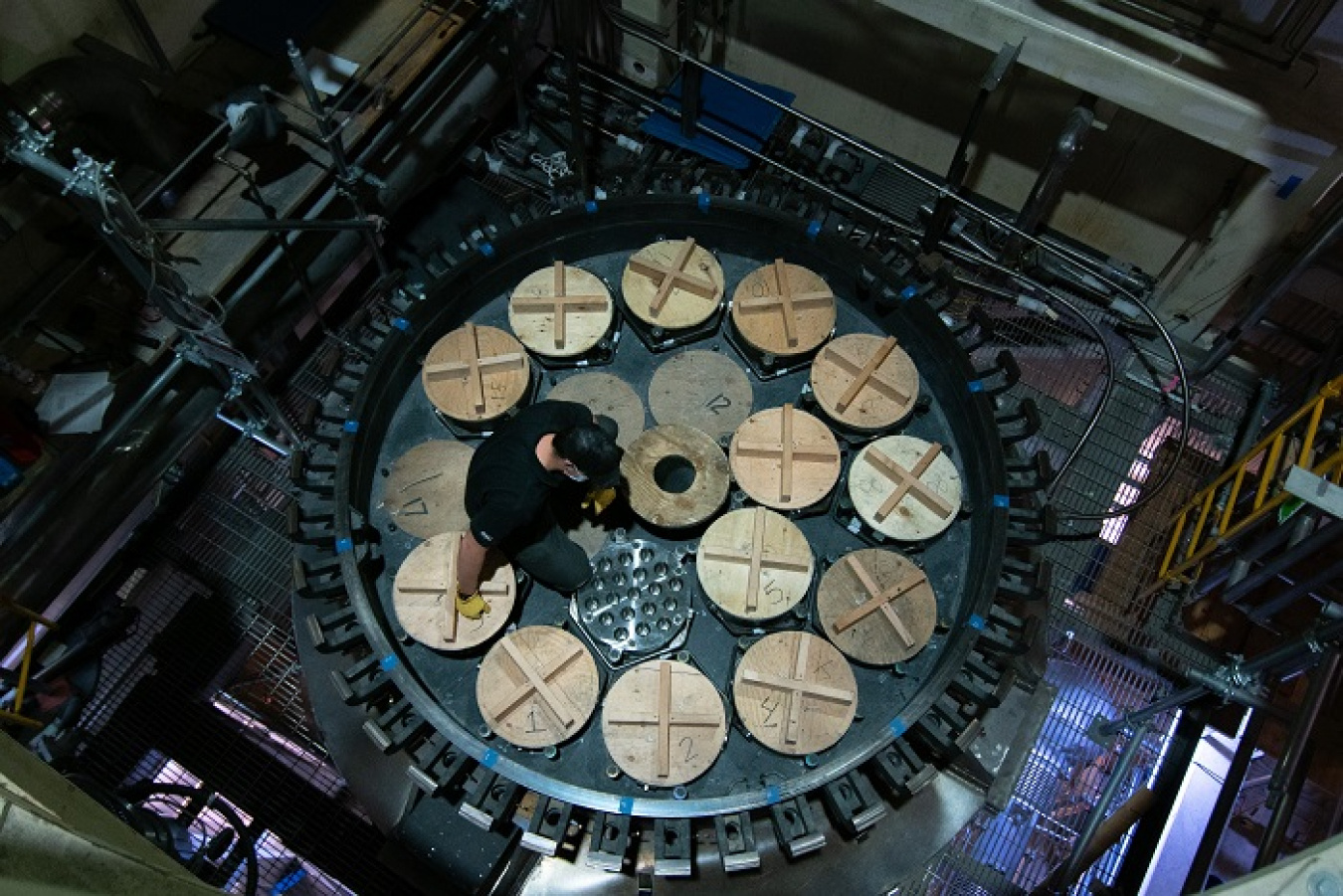A Fluor Idaho employee kneels atop the process gas filter (PGF) at the Integrated Waste Treatment Unit.