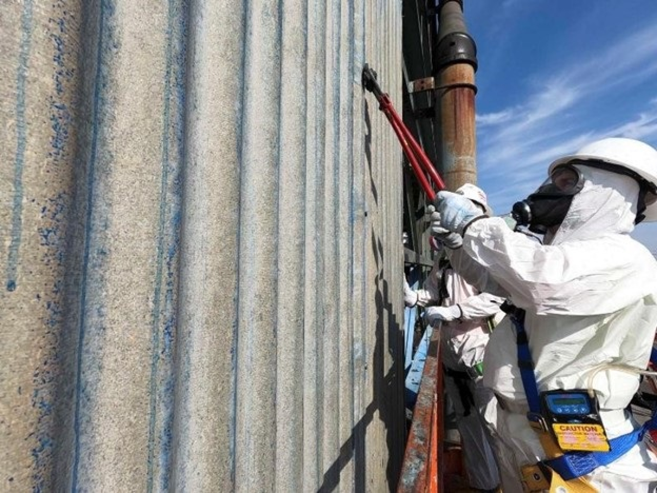 This remotely captured photograph shows Portsmouth Site workers snipping the bolts near the top of the X-326 Process Building prior to removal of a transite-siding panel. Structural demolition of the building begins this year.