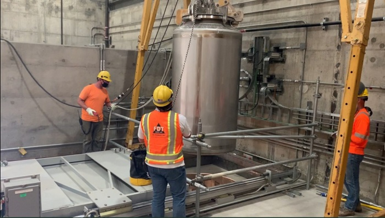 Workers at Hanford’s Waste Treatment and Immobilization Plant manipulate an empty container that will be filled with waste immobilized in glass when the plant begins treating Hanford’s tank waste following commissioning of facilities.