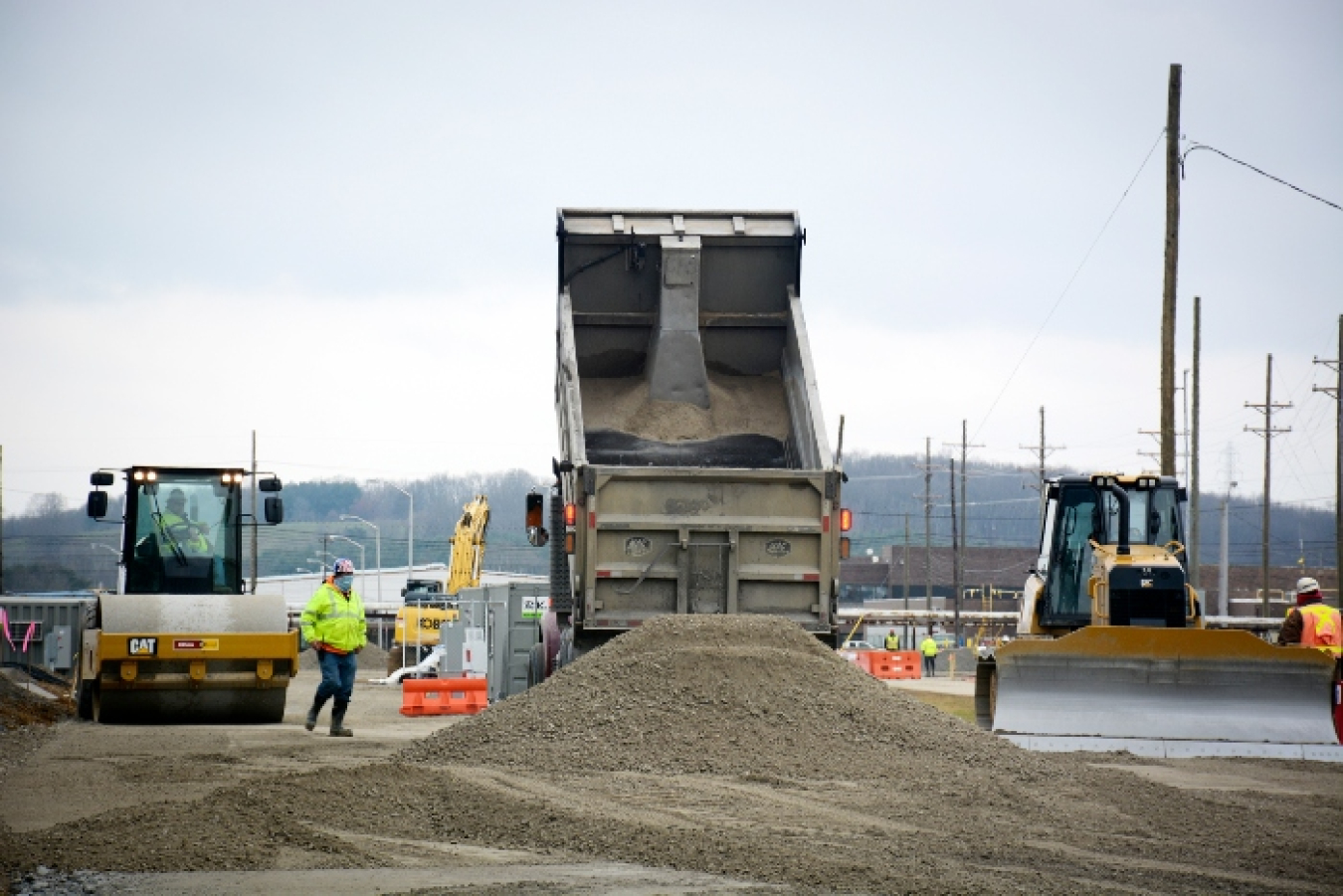 Crews deliver a load of dirt near the X-326 building as work continued on haul road construction.