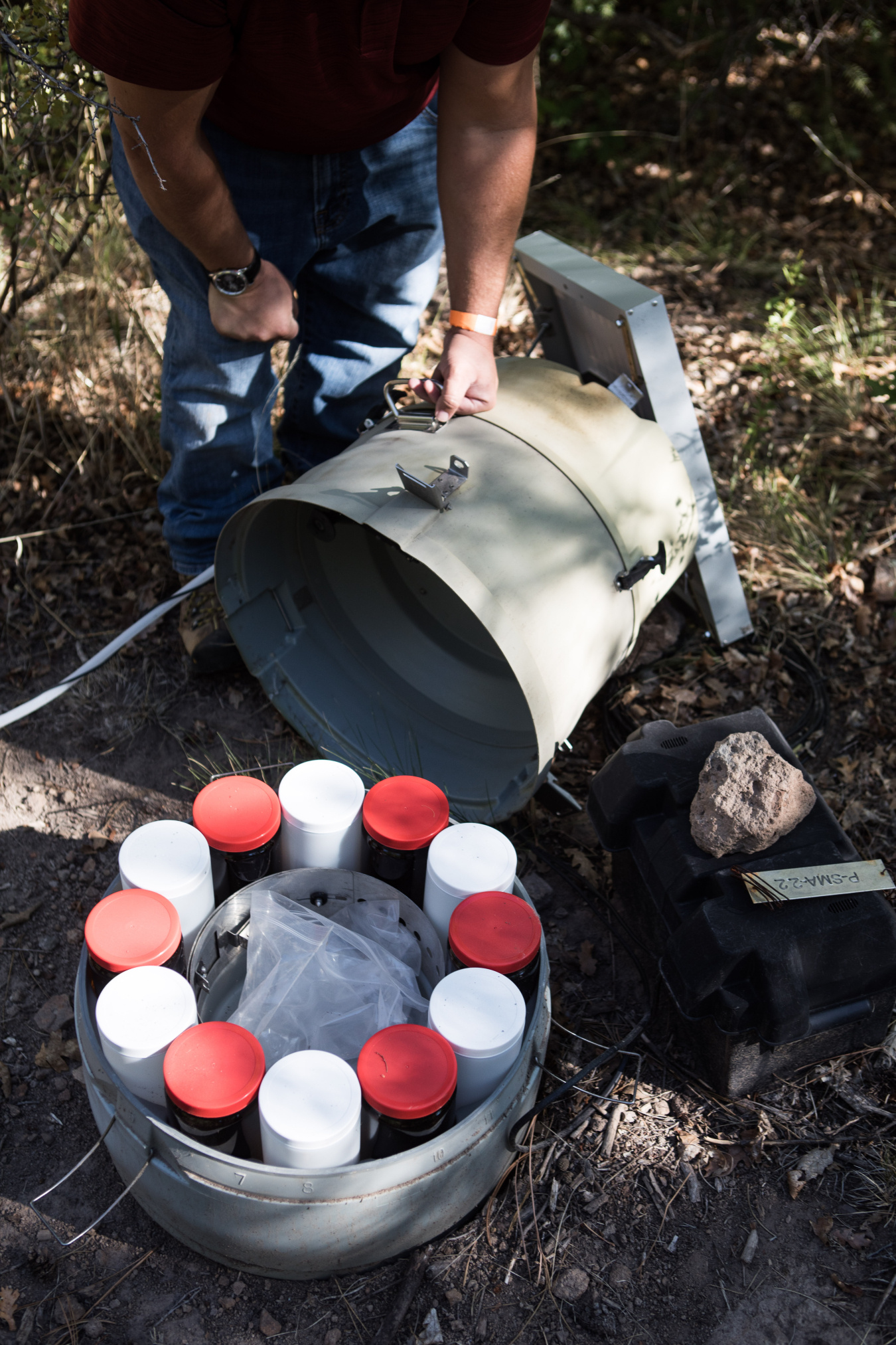 A stormwater sampling station in Pueblo Canyon is inspected by an environmental professional.