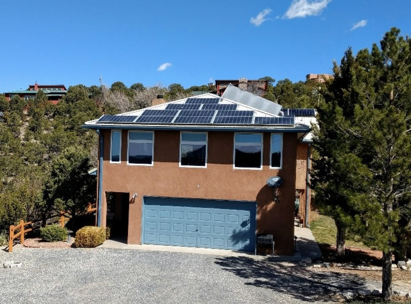“Wayne’s World” from the south side. The was taken in the late morning on the equinox. The sun barely makes it to the bottom of the windows, so there will be no direct solar gain on the south side from April to October. The one large roof panel is a solar hot water panel, and the rest are solar electric. The thin windows on the side of the building allow the sun to heat the thermal walls.