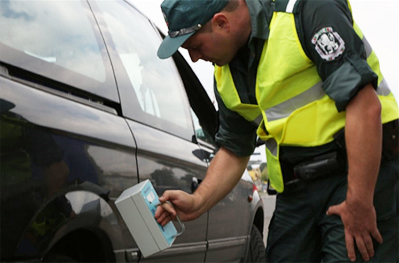 A front-line officer in Bulgaria performs a vehicle inspection with a portable radiation detection system.