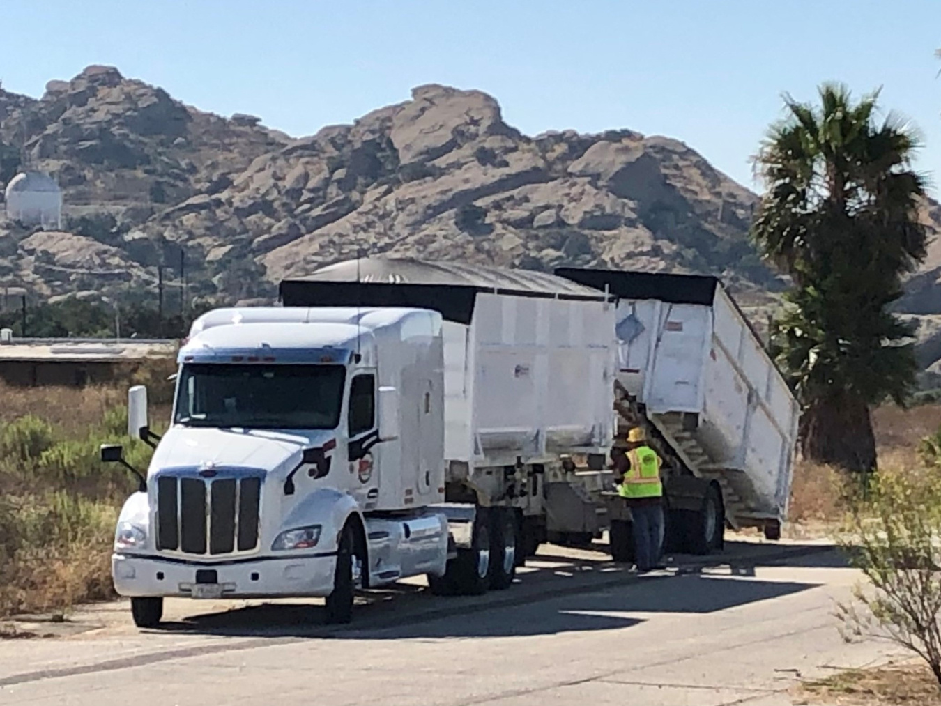 Building debris is loaded onto a truck to be hauled off-site for disposal.