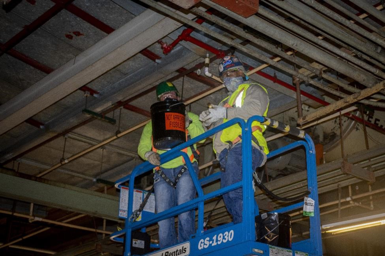 Crews work on sprinkler heads as part of the modifications made to the sprinkler system in the C-333 Process Building. The new dry hybrid fire suppression system helps reduce the amount of energy needed to maintain the sprinkler system.