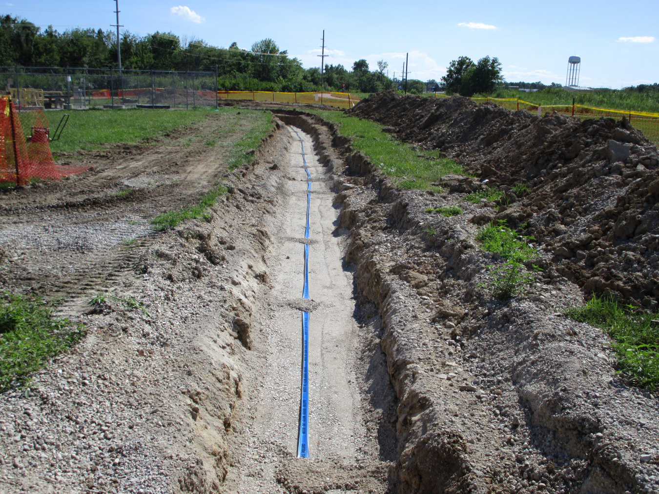 The blue magnetic locator tape seen here below fill and water will allow future detection once the trench is fully filled and covered. 