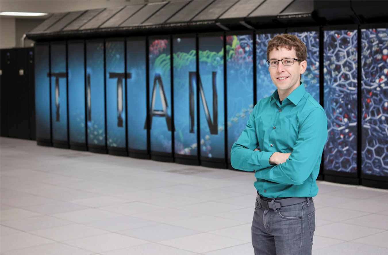 Seth Johnson stands in front of an Oak Ridge National Laboratory supercomputer.