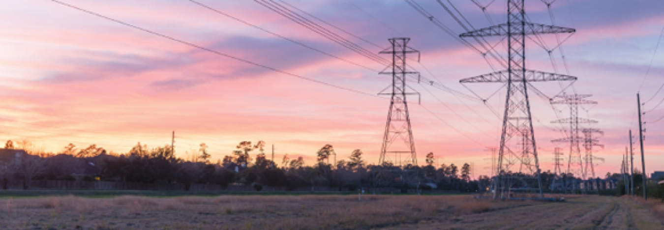 Image of power lines silhouetted by a sunset sky.