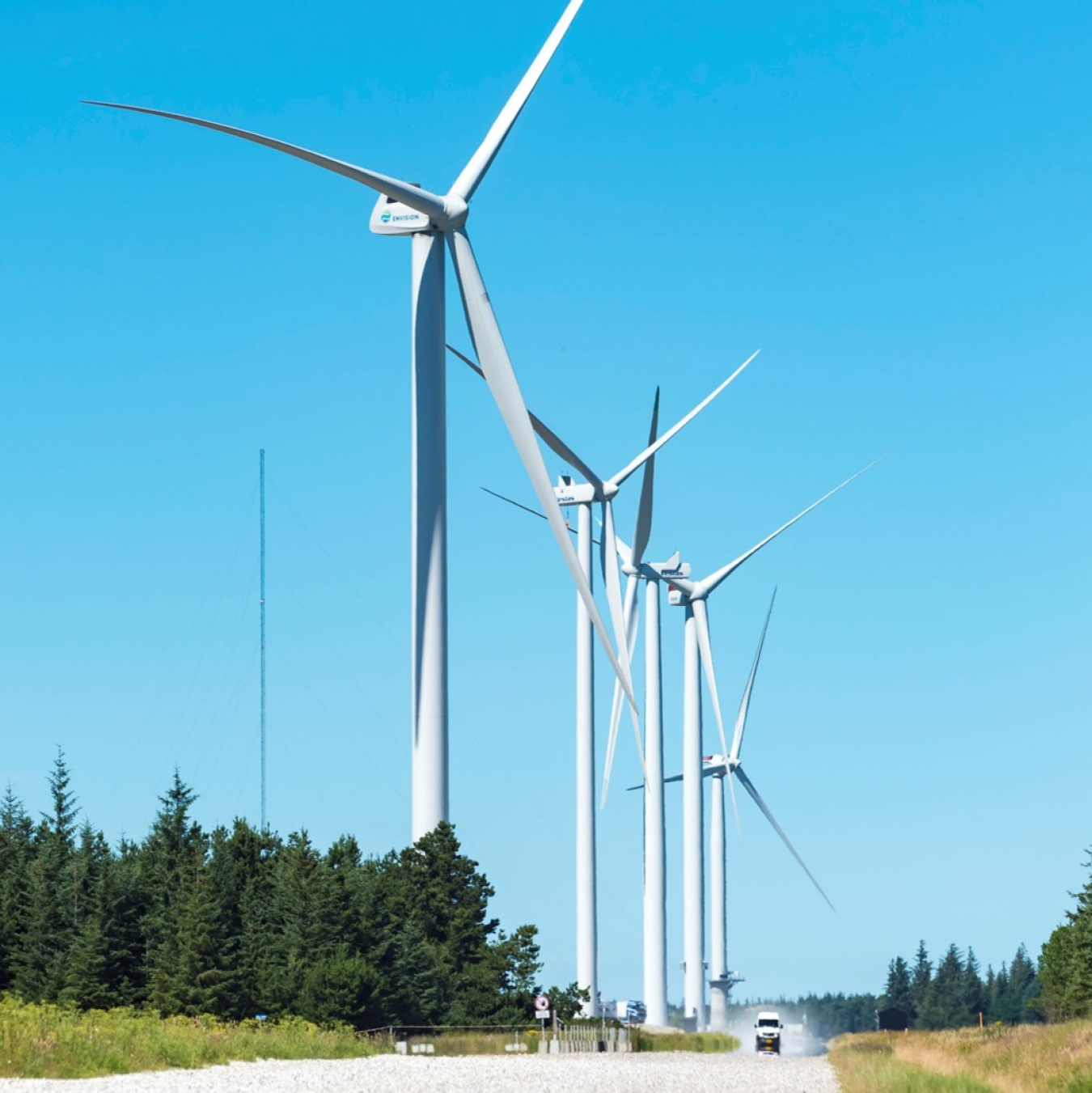 DTU test site of wind turbines against a sunny cloudless sky.