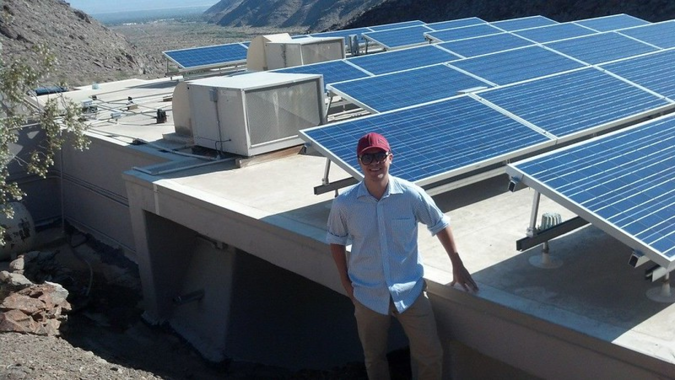 Tommy Jones standing in front of PV panels.