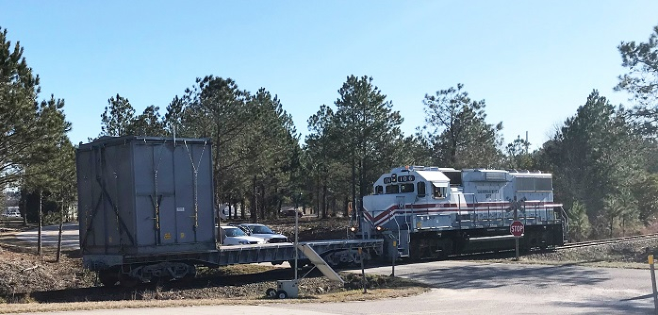 A train pushes a container full of old equipment from H Canyon to the Solid Waste Management Facility for disposal at the Savannah River Site. The equipment is being removed to make way for a new H Canyon spent nuclear fuel dissolving campaign.
