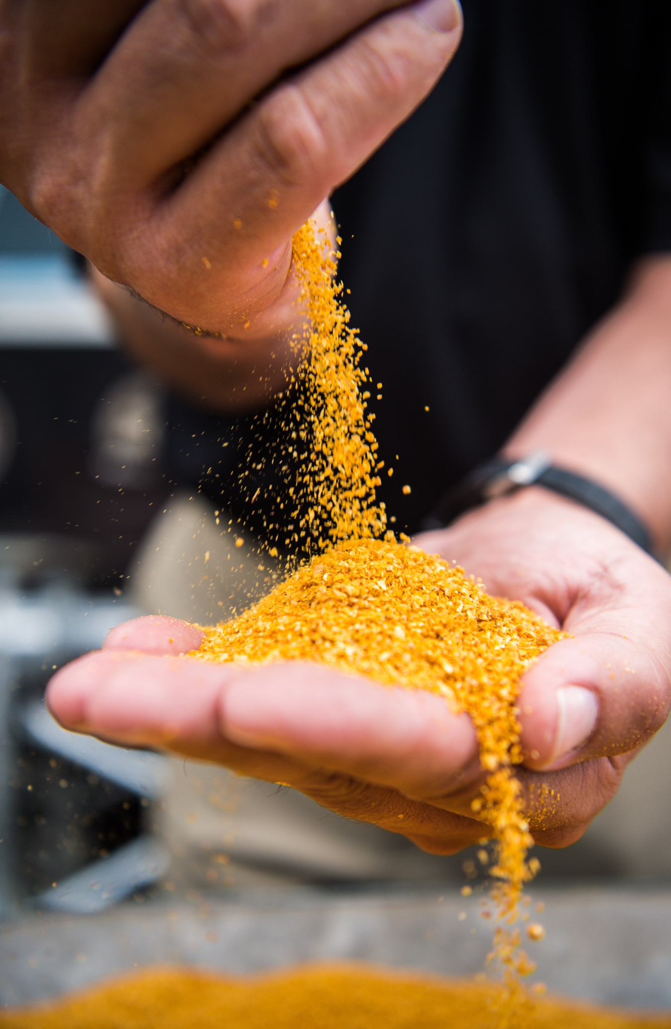 Close up of someone pouring corn from one hand to another.