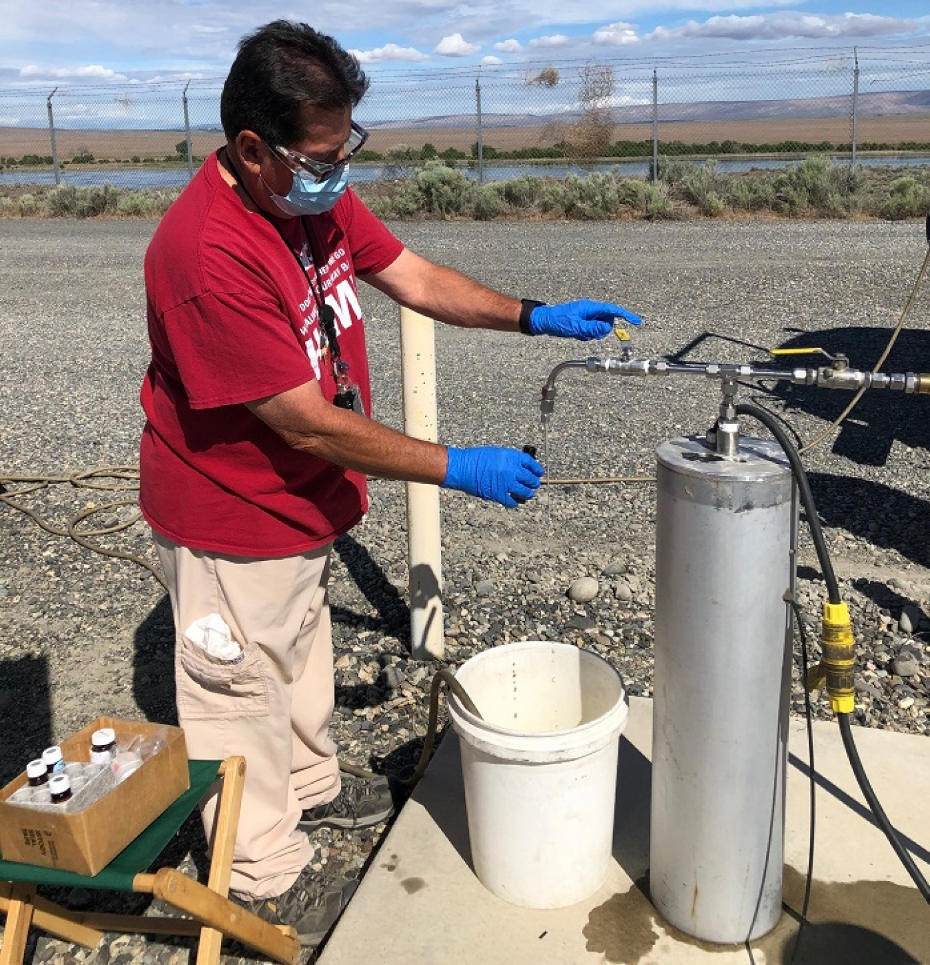 Juan Aguilar with EM contractor Central Plateau Cleanup Company collects a groundwater sample from a monitoring well near the Columbia River. Sampling data has shown a significant reduction in contamination along the river over the past decade.