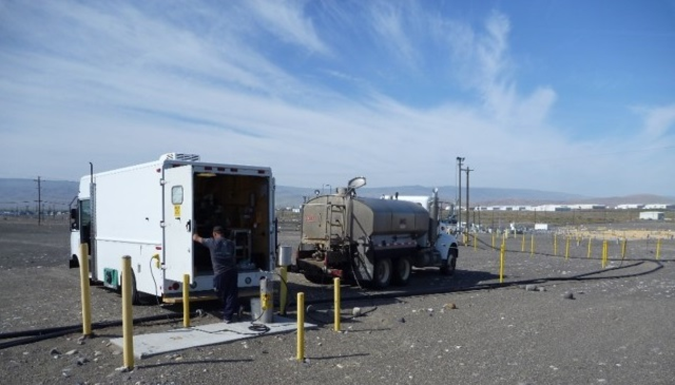 A team with EM contractor Central Plateau Cleanup Company prepares to collect groundwater samples from a monitoring well near the center of the 580-square-mile Hanford Site. Each year, field crews log more than 80,000 miles visiting about 2,400 wells and collecting up to 25,000 soil and groundwater samples, which are shipped to a laboratory for analysis. 