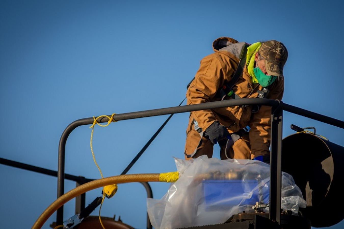 Paducah Site worker Cayce King connects a hose to a rail car to drain oil from the C-531 switchyard. Each rail car can hold approximately 25,000 gallons of oil.