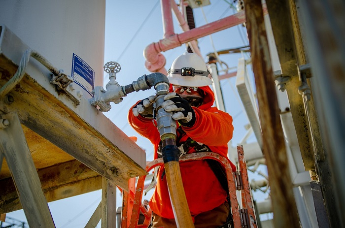 Paducah Site worker Matt Gill hooks up a hose to a switchyard electrical component to pump oil into rail cars for transfer to the Paducah Area Community Reuse Organization.