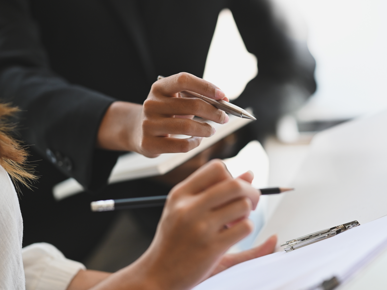 Closeup two woman consulting with paperwork document report.