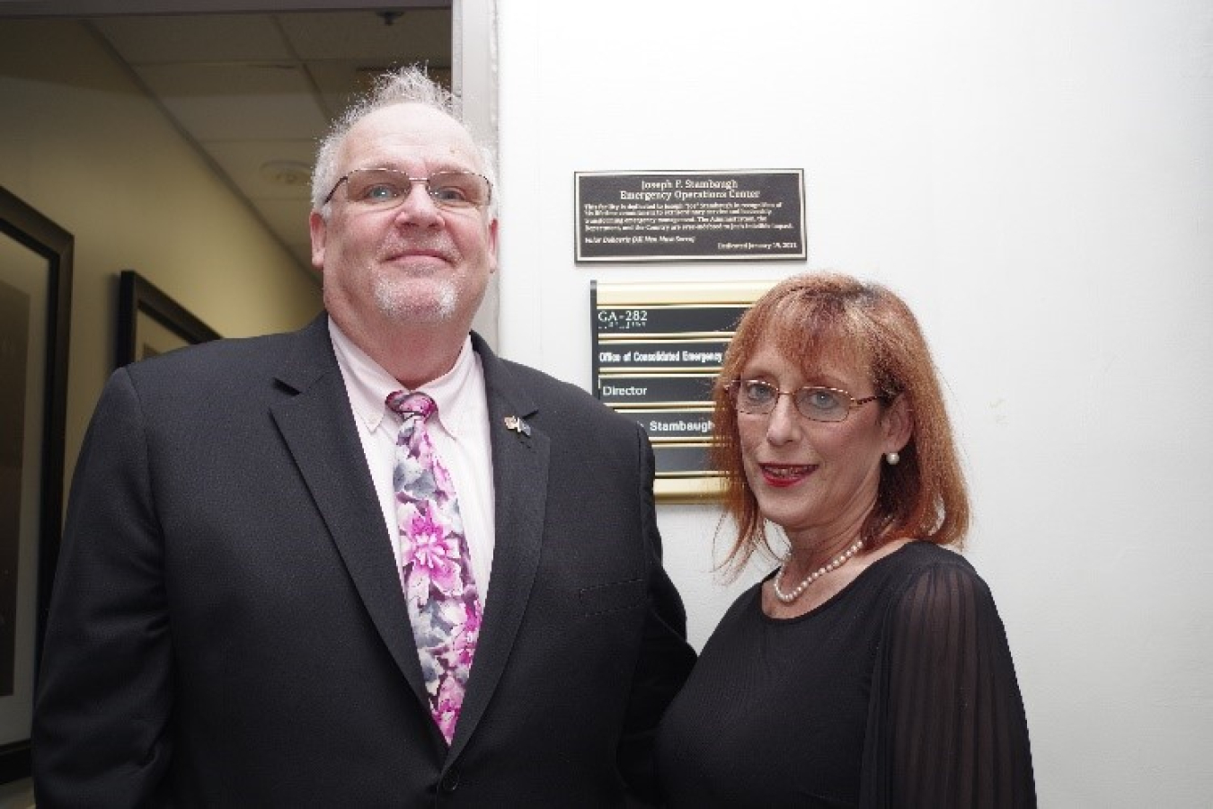 Joe Stambaugh with his wife, Lisa, proudly posing in front of the CEOC dedication plaque