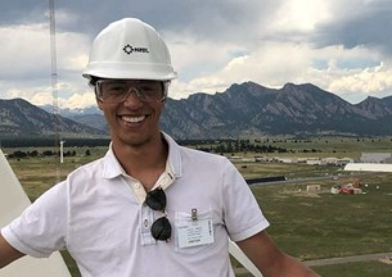 Headshot of a male smiling with a hard hat on.