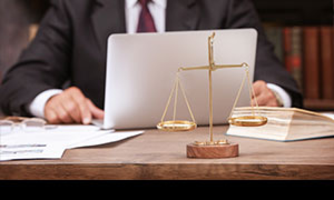 a photo of a person on a laptop at a desk.