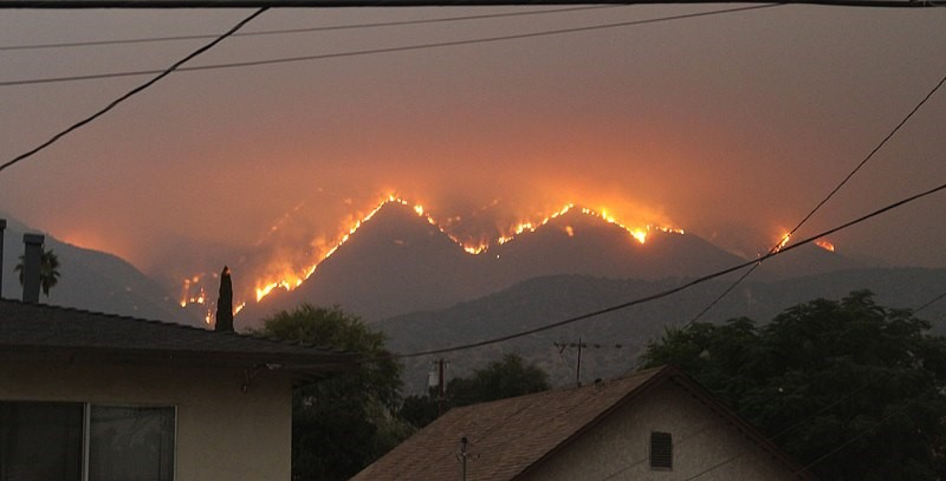 A picture of a hillside on fire in the distance