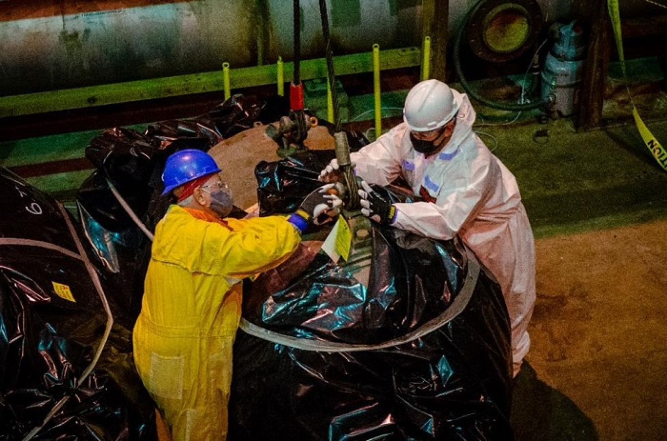 Workers rig a motor to be removed from the Paducah Site’s C-333 Process Building onto the hoist of a high bay crane. Motors were removed to make room for the material sizing area inside the building.