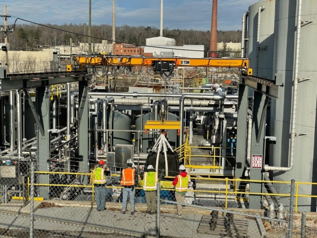 Workers observe the installation of the final components of a new zeolite treatment system designed to strip contaminants from wastewater at Oak Ridge.