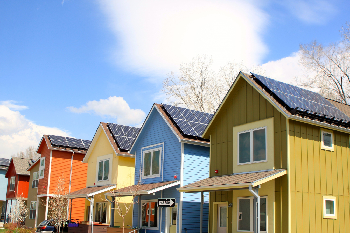 A row of colorful houses with rooftop solar panels