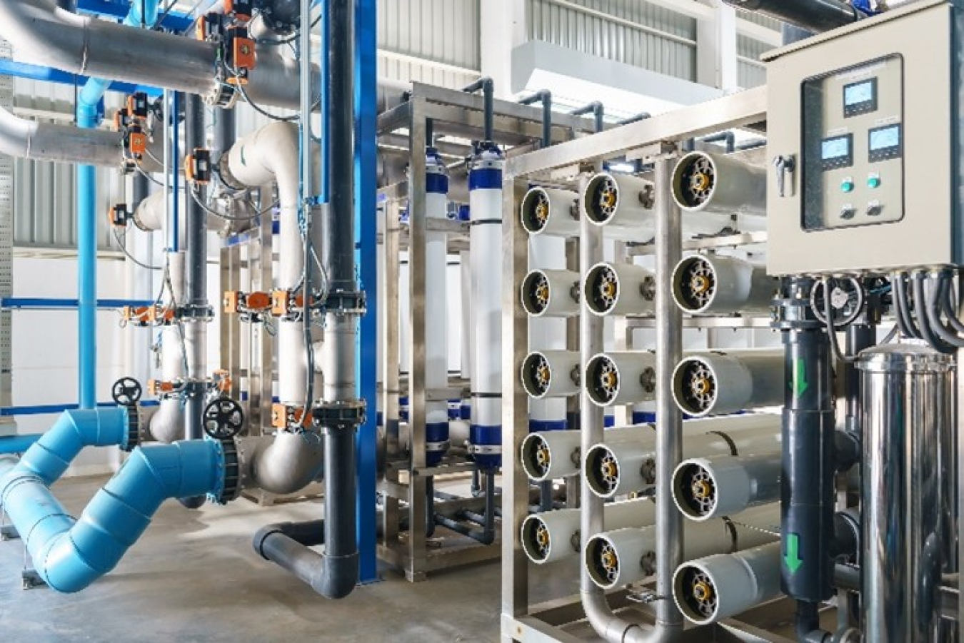 a photo inside a boiler room, with lots of pipes and a computers.