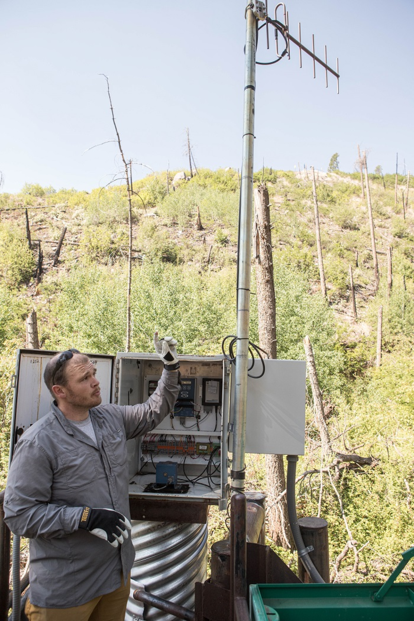 Field Technician Luke Simms inspects an automated sampler that collects stormwater in Santa Fe National Forest’s Water Canyon, where a burn scar remains after the Las Conchas fire in 2011. The sampler lies upgradient from Los Alamos National Laboratory and assists environmental professionals in assessing metal, radioactivity, and organic compound levels naturally occurring in the environment.