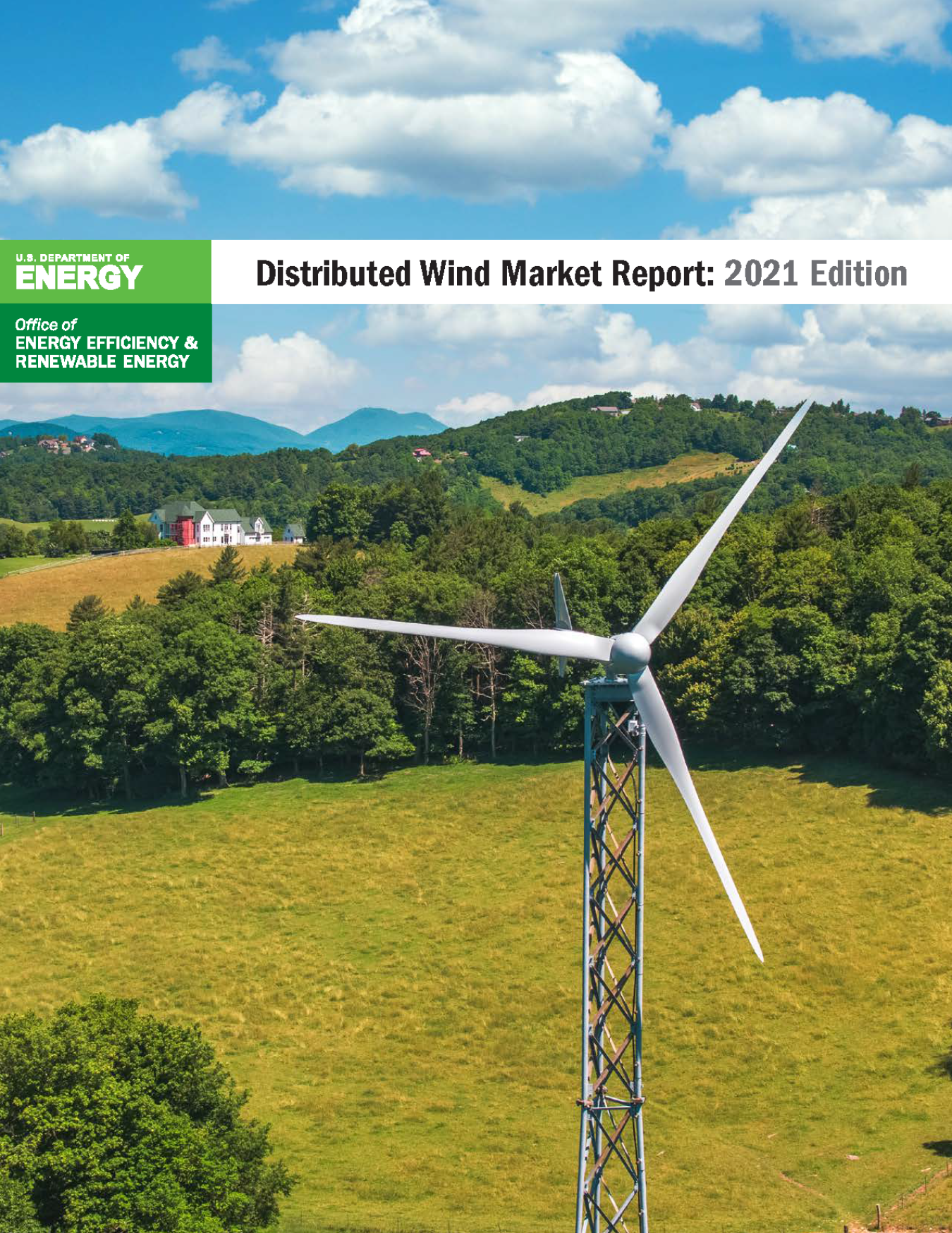 Mountains and trees with a distributed wind turbine in the foreground.