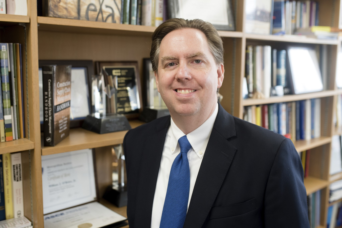 Head-and-shoulders photo of William O'Brien in his office with bookcases in the background.