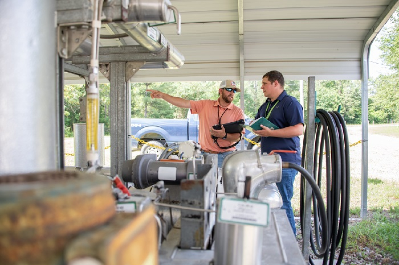 F Area Operator Thomas Harman, left, and Savannah River Nuclear Solutions Scientist Kevin Boerstler check the pumps, sensors, and piping that blend an environmentally harmless base solution to inject into acidic groundwater at Savannah River Site, part of the site’s environmental remediation strategy.