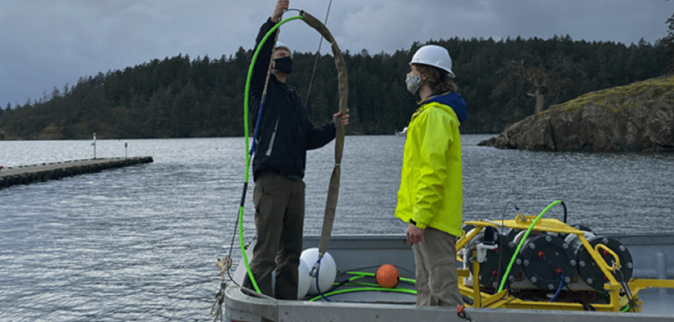 Two men on a boat setting up equipment. 